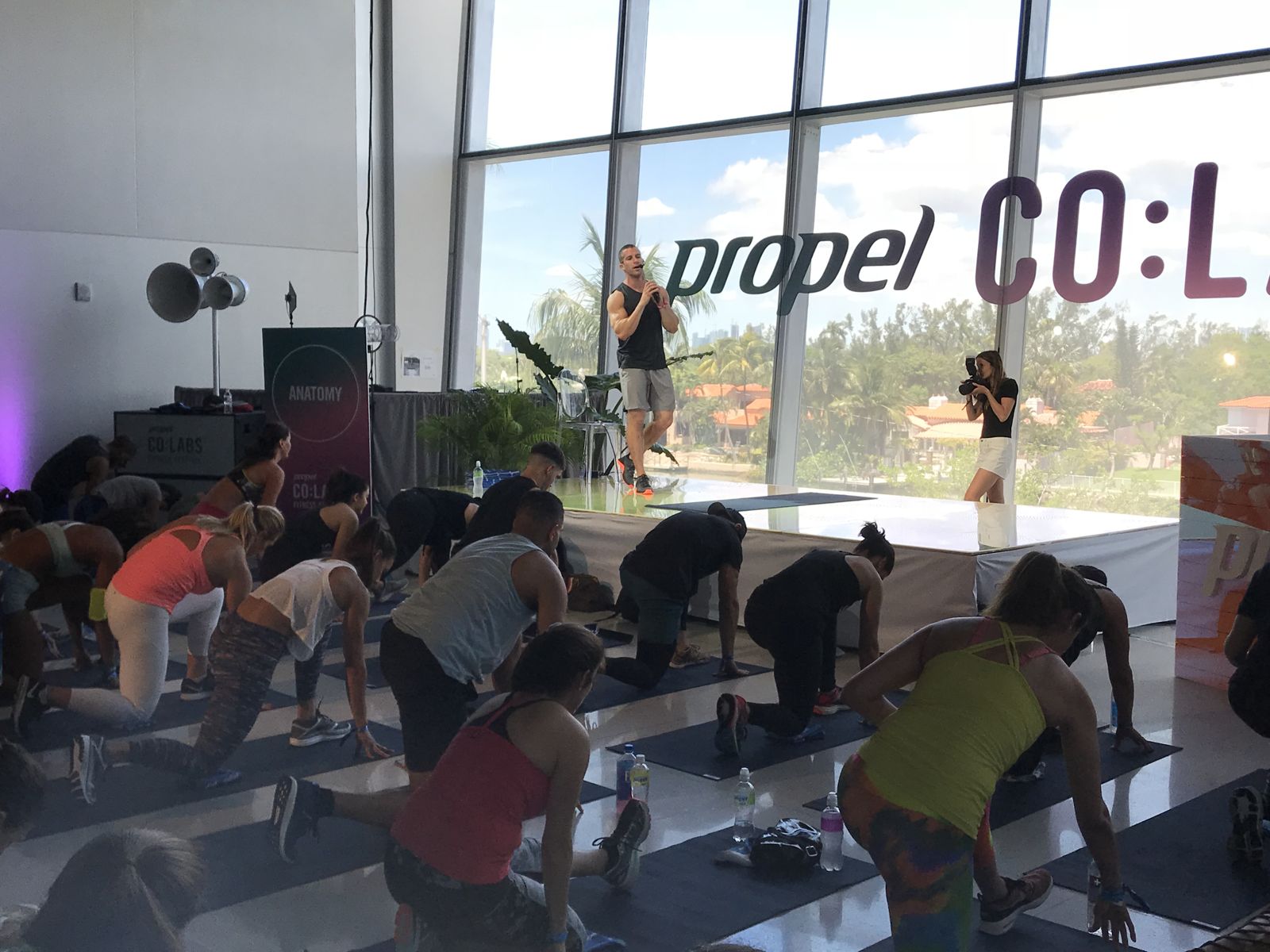 Grant Weeditz cueing a kneeling class with a microphone at Propel CO:LABS, Faena