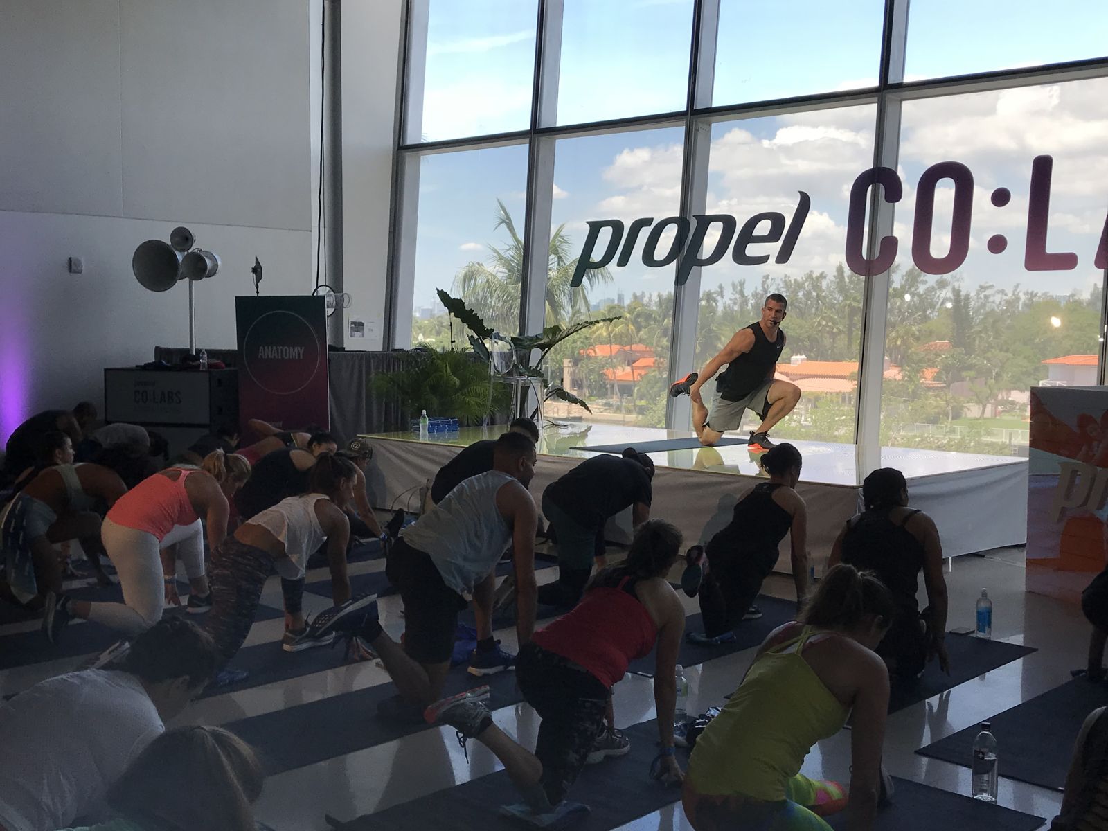 Grant Weeditz demonstrating a lunge on stage as the class follows at Propel CO:LABS, Faena