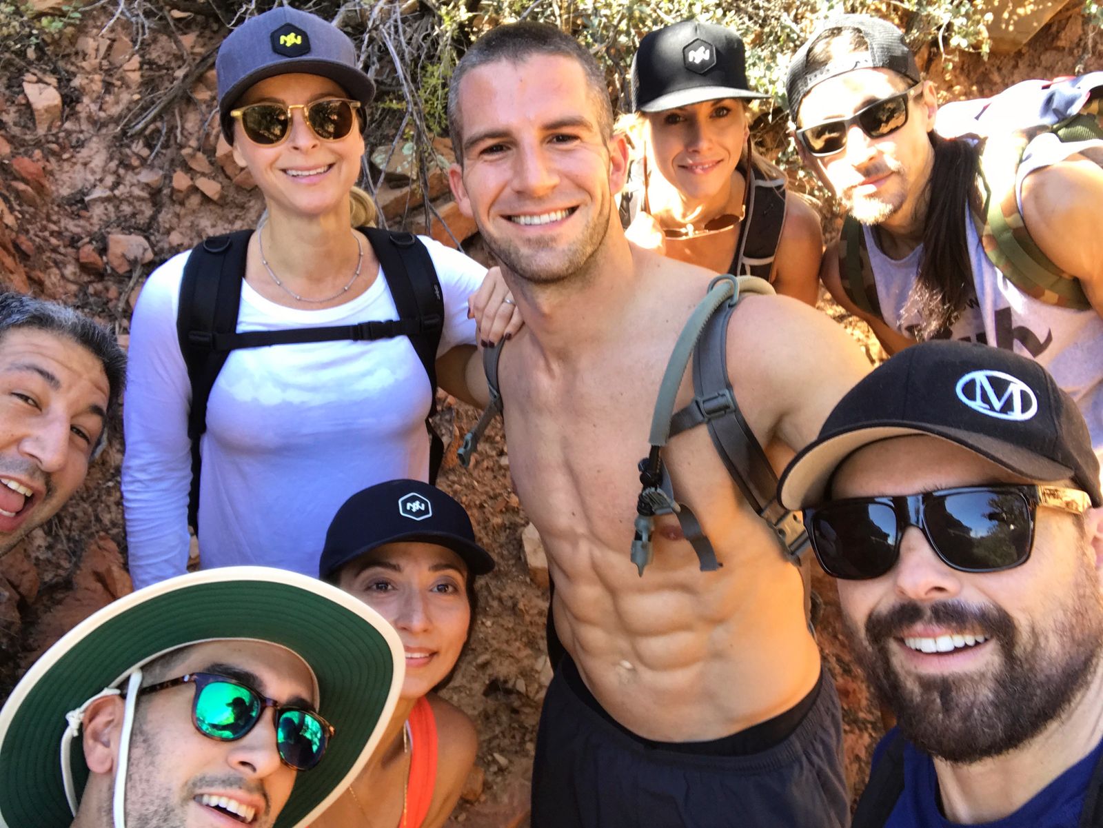 Group selfie of the Onnit Academy team on a red-rock trail in Sedona, Arizona